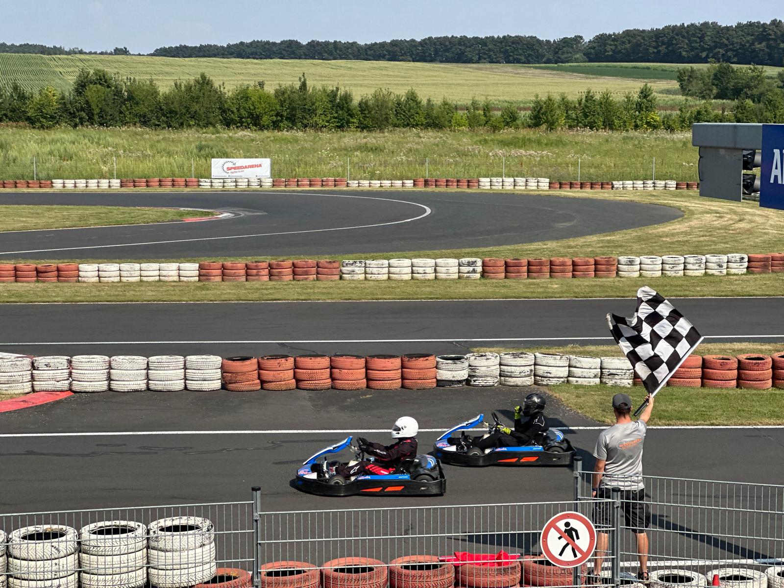 Zieleinlauf mit karierter Flagge beim Abschlussrennen des Kart Feriencamps